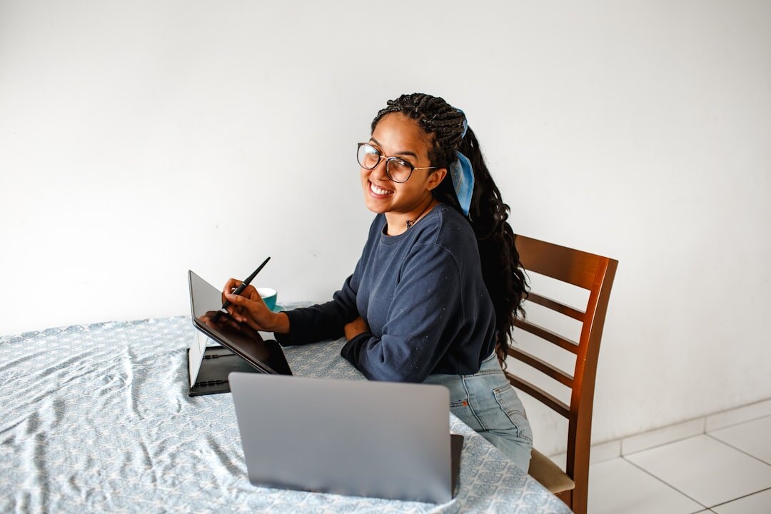 Brazilian woman smiling while writing a message on a laptop