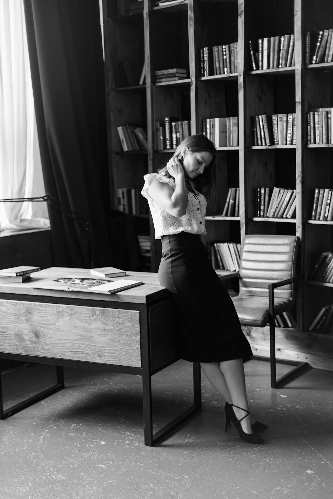 Brazilian woman writing thoughtfully at a sunlit desk with books