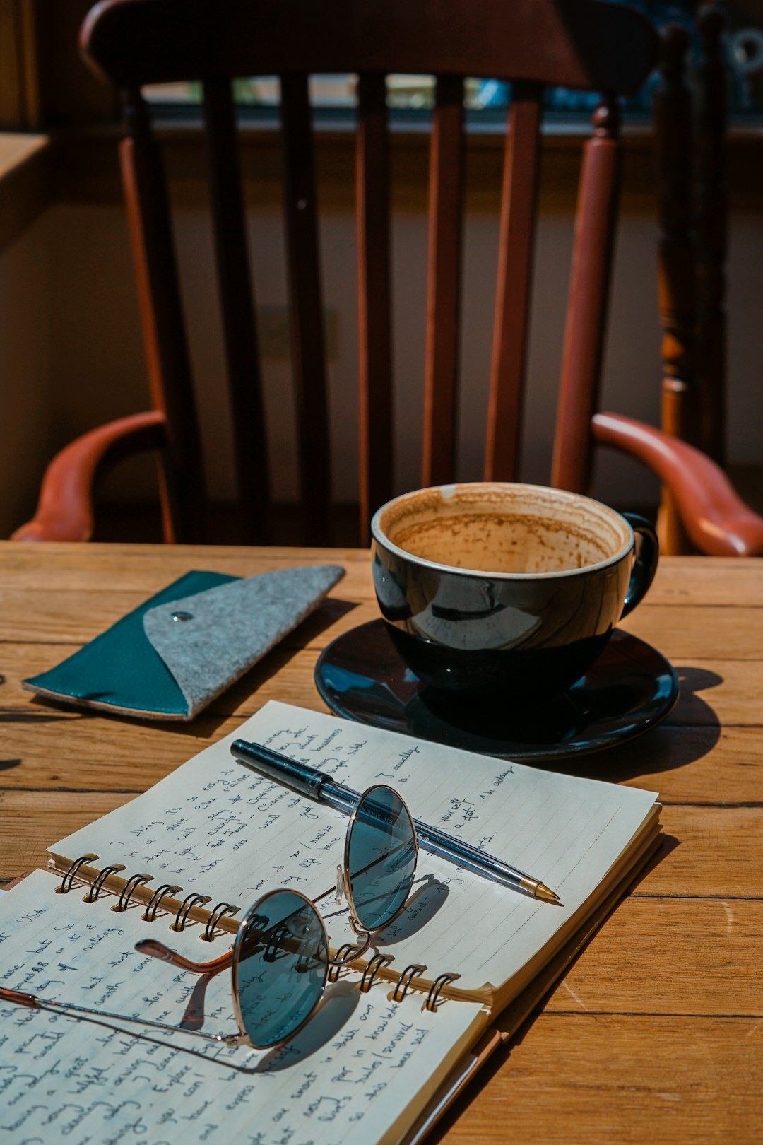 Close-up of an open journal with handwritten notes and coffee