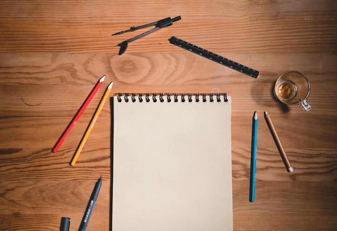 Flat lay of an open notebook, pen and coffee cup on a wooden table